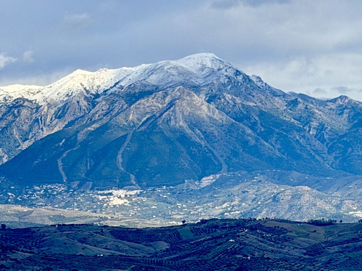 De besneeuwde top van La Maroma boven de vallei