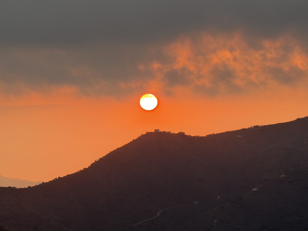 Zonsondergang boven de heuvels richting de kust
